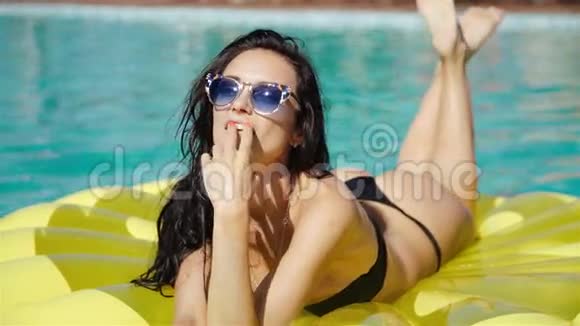 穿比基尼的女人在度假期间在游泳池里喝鸡尾酒享受夏日阳光和晒黑泳池里的女人视频的预览图