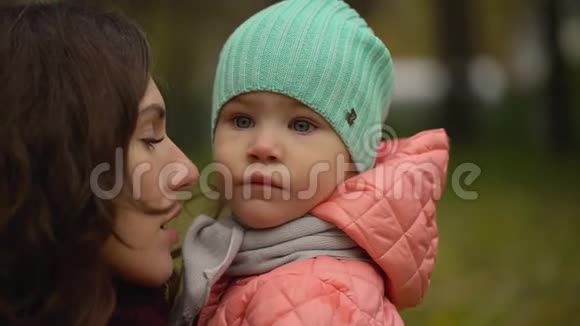 秋天公园里有个孩子的美丽年轻女人的肖像两个年轻母女的肖像慢慢慢慢视频的预览图