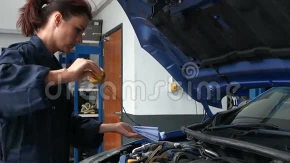 女机械师检查发动机中的油视频的预览图