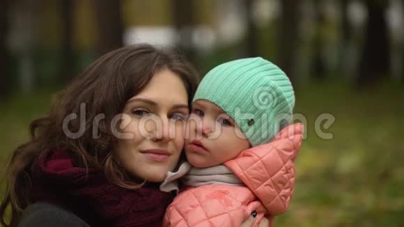 秋天公园里有个孩子的美丽年轻女人的肖像两个年轻母女的肖像慢慢慢慢视频的预览图