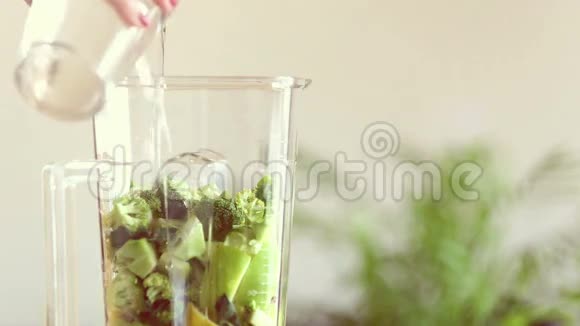 将水倒入水果和蔬菜的搅拌机中视频的预览图