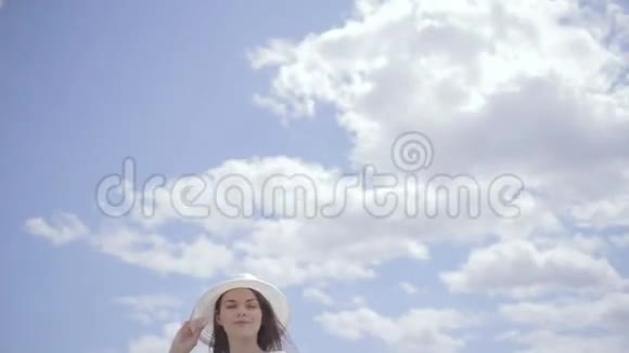 一个年轻漂亮的女人在水边天空满是云视频的预览图