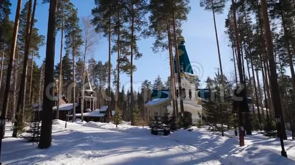 降雪后在基督教教堂的背景下用白雪覆盖的树木呈现冬季景观寒冷的晴天视频的预览图