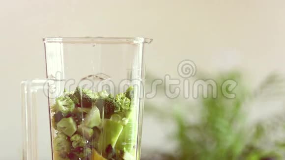 将水倒入水果和蔬菜的搅拌机中视频的预览图