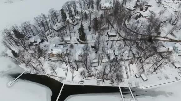 在冰雪覆盖的房屋上飞翔在冰冻的湖滨视频的预览图
