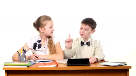 学校的孩子们坐在桌子旁做着视频的预览图
