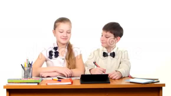 学校的孩子们坐在桌子旁做视频的预览图