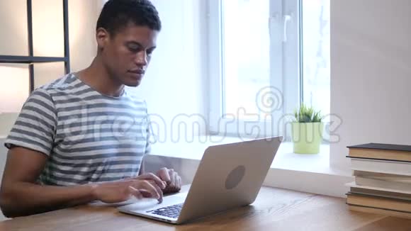 年轻的黑人因失去而心烦意乱在笔记本电脑上工作视频的预览图