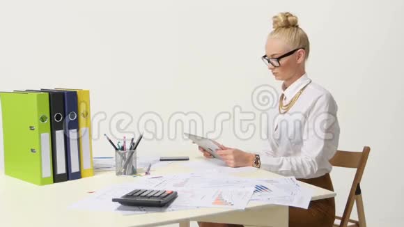 坐在办公桌前穿休闲衬衫的女商人视频的预览图