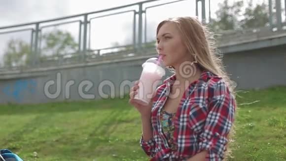 在街上喝健康奶昔的年轻女子视频的预览图