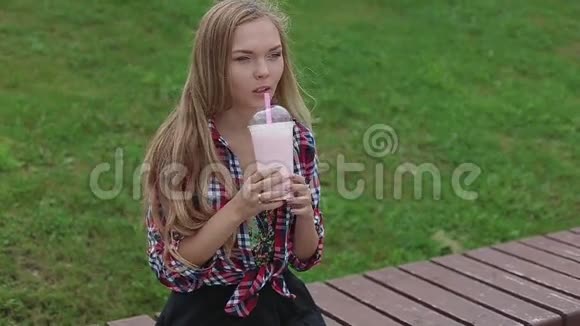 在街上喝健康奶昔的年轻女子视频的预览图