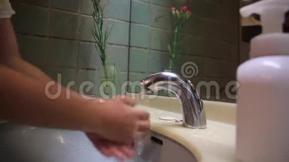 小孩的手在水龙头清洗和烘干他的手视频的预览图