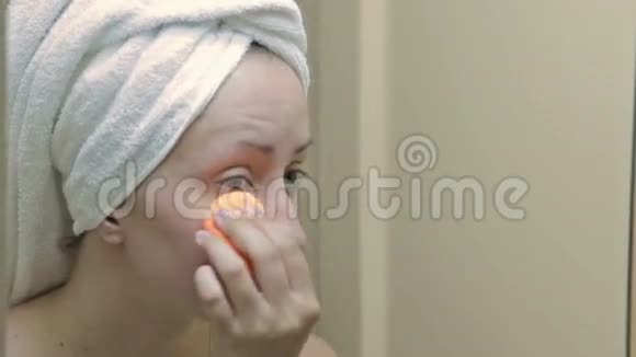 年轻漂亮的女人在浴室里用遮瑕膏视频的预览图