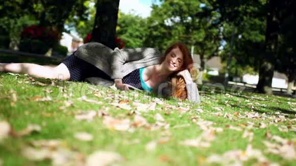 平静的红发人躺在绿色的草坪上视频的预览图