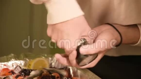 在家庭厨房里一个女孩的手在手工磨坊的一个戳子里放着一个盘子或胡椒健康视频的预览图