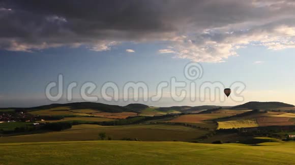 日落时分热气球飞过高尔夫球场和山谷视频的预览图