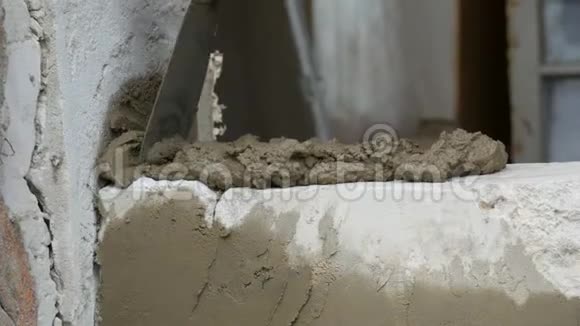 男建造商在水泥和立墙上铺设白砖人类的双手把建筑砖铺在近景上视频的预览图