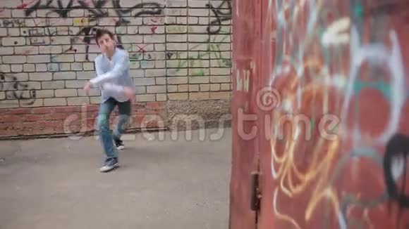 少年跳舞在砖墙的背景上跳舞视频的预览图