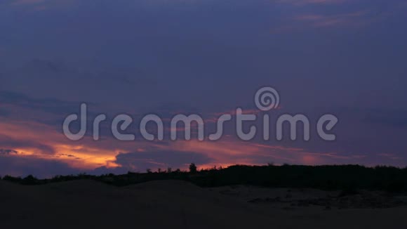 美丽的紫黄色夕阳映衬着森林的轮廓时光流逝视频的预览图