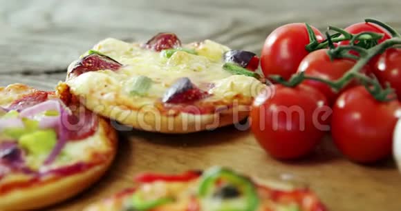 木制桌子上有蔬菜和香料的意大利披萨视频的预览图
