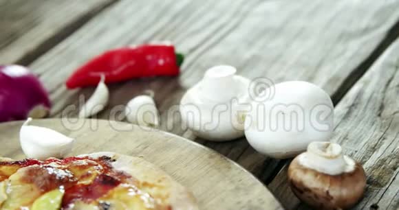 木制桌子上有蔬菜和香料的意大利披萨视频的预览图