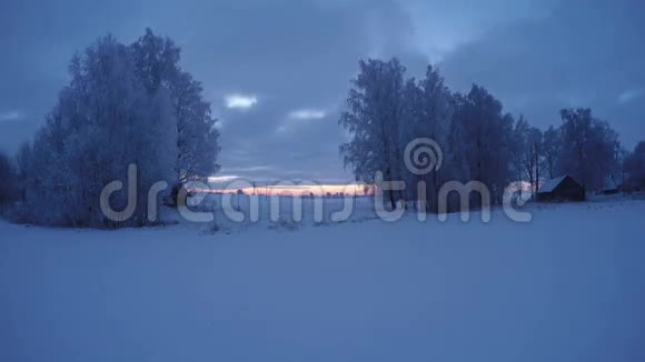 日出时树木覆盖着霜冻和木屋时间流逝4K视频的预览图