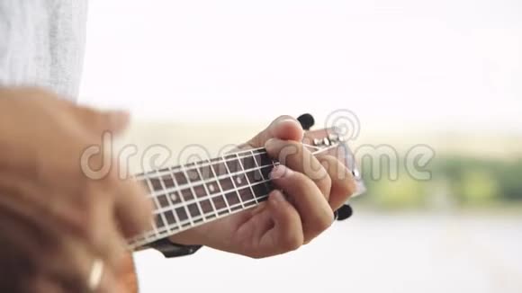 演奏小四弦琴吉他的人视频的预览图