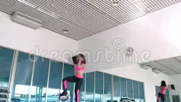 笑容可掬的女人在体育馆里穿着袋鼠鞋跳视频的预览图