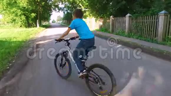 小男孩骑着运动自行车摄像机在他身后以稳定的姿态移动视频的预览图