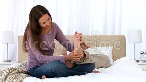 可爱的女人按摩她男朋友的脚视频的预览图