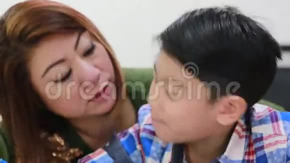 快乐的亚洲家庭男孩和父母一起看手机视频的预览图