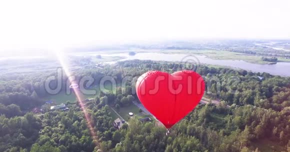 红色热气球在空气中呈心形四周看空中视频的预览图