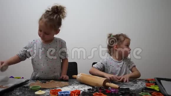 快乐的双胞胎女孩在厨房准备饼干在现实生活中的休闲生活照片圣诞饼干视频的预览图