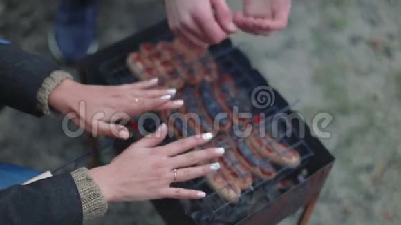 热烤架上的烧烤棕色香肠暖手特写视频的预览图