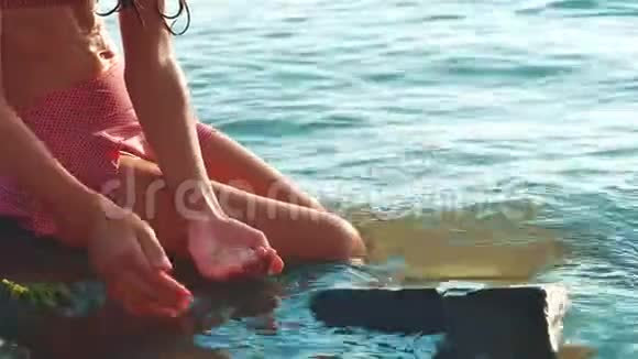 小女孩用石头和生活方式的石头在海里洗澡少女女儿在海浪中游泳视频的预览图