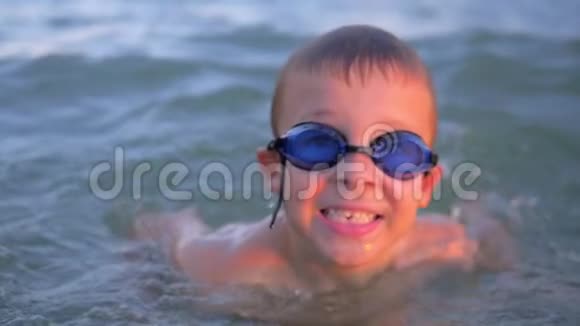 戴护目镜的快乐男孩在海中沐浴视频的预览图
