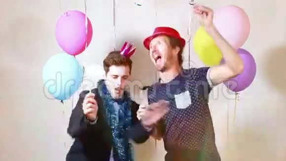两个快乐的男人在摄影棚里用道具跳舞视频的预览图