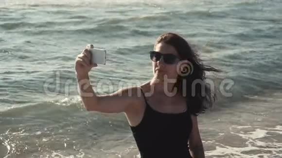 迷人的女孩在海岸上自拍视频的预览图
