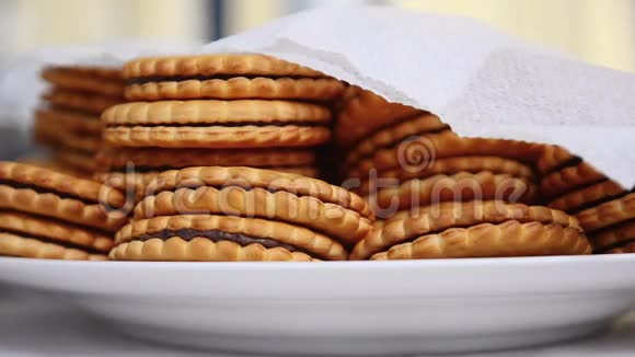 许多带有巧克力的饼干躺在被餐巾覆盖的白色盘子里视频的预览图