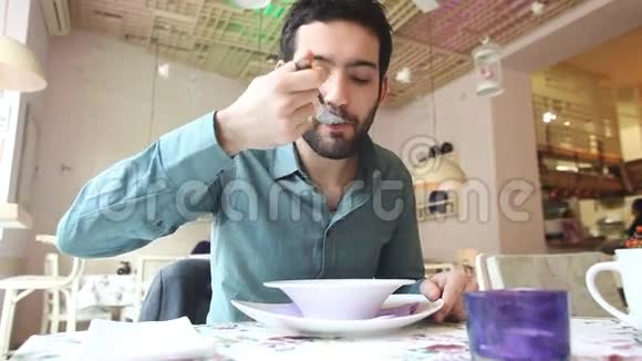 一个英俊的年轻人在一家餐馆喝汤视频的预览图