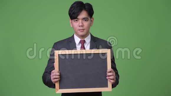 年轻英俊的亚洲商人展示黑板视频的预览图