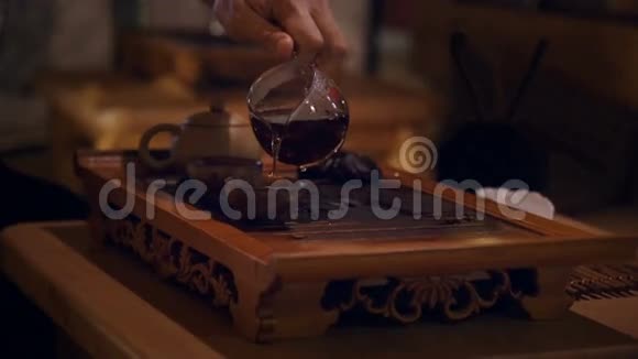 双手将茶从玻璃壶中倒入两杯视频的预览图