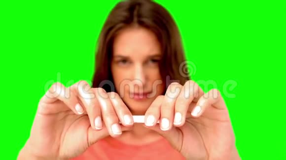 一个女人在绿色屏幕上折断了一根香烟视频的预览图