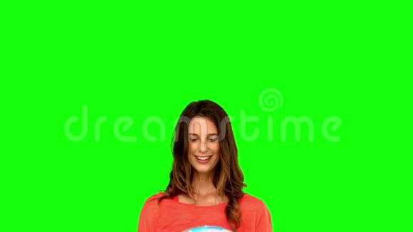 在绿色屏幕上扔地球仪的女人视频的预览图