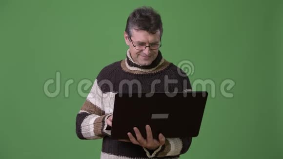 成熟的帅哥穿着绿色背景的高领毛衣视频的预览图