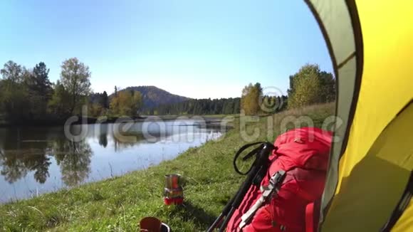 这顶黄色的帐篷在山湖畔卖红色背包和旅游靴视频的预览图