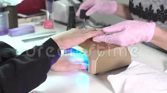 一位美容师给一位正在做指甲修指甲的女士做的特写视频的预览图