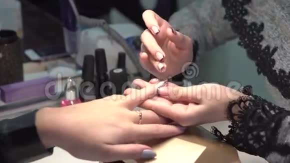 一位美容师给一位正在做指甲修指甲的女士做的特写视频的预览图