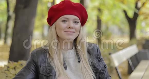 穿红色贝雷帽的女人坐在长凳上视频的预览图
