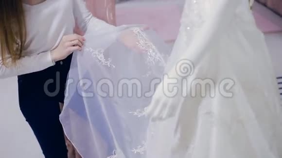 年轻女子在婚纱店挑选婚纱视频的预览图